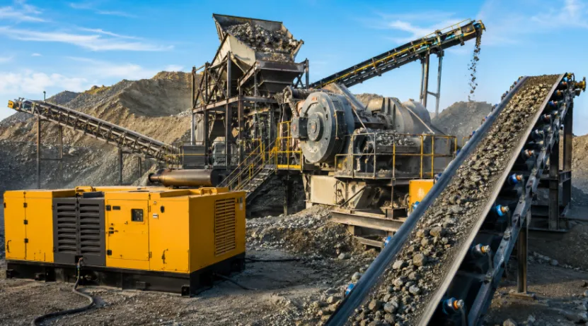 Yellow generator powering a rock crusher and conveyor belt